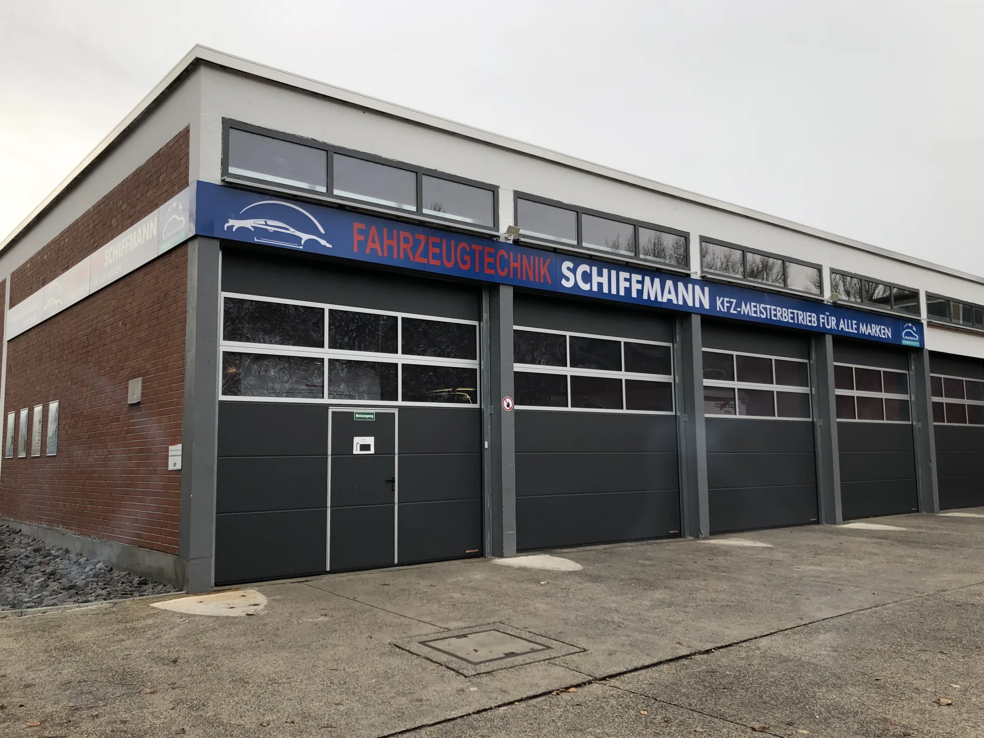 Werkstattgebäude von Fahrzeugtechnik Schiffmann mit Schriftzug über den Hallentoren